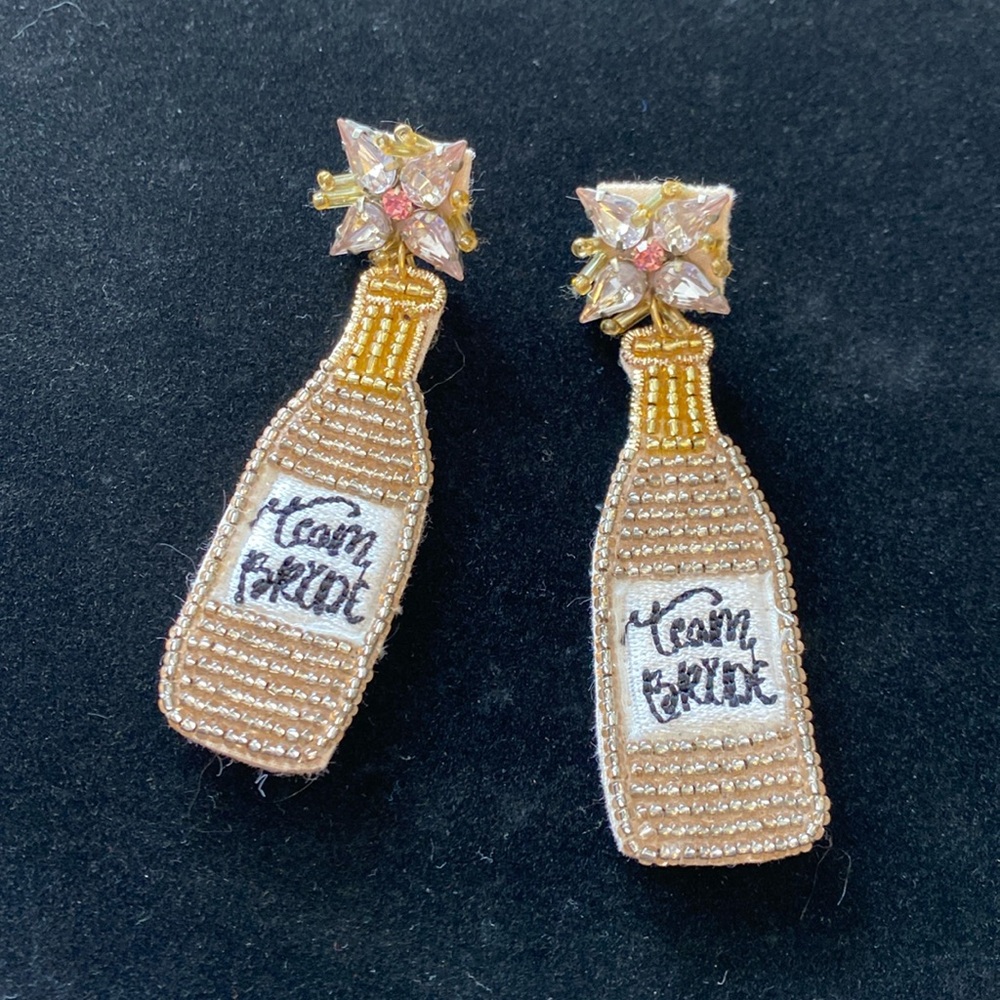 Team Bride rose colored champagne bottles.